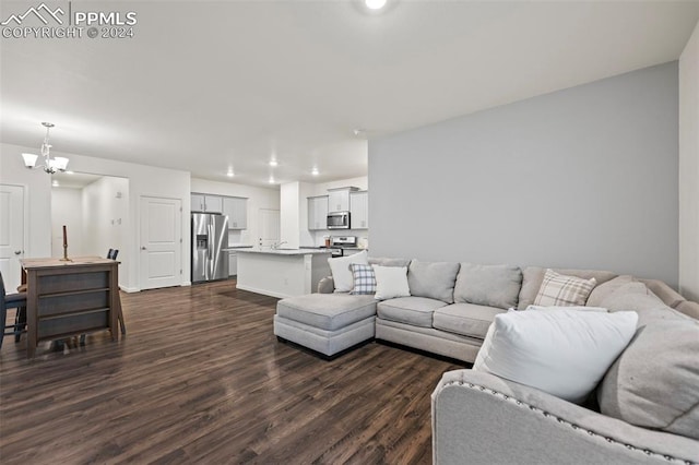 living room with an inviting chandelier and dark hardwood / wood-style flooring