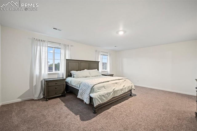 bedroom featuring multiple windows and dark colored carpet