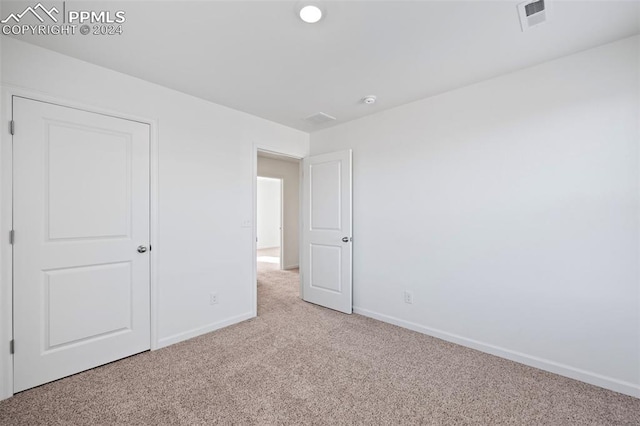 unfurnished bedroom with light colored carpet