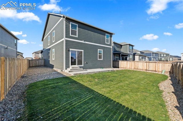 back of house featuring a yard and a patio