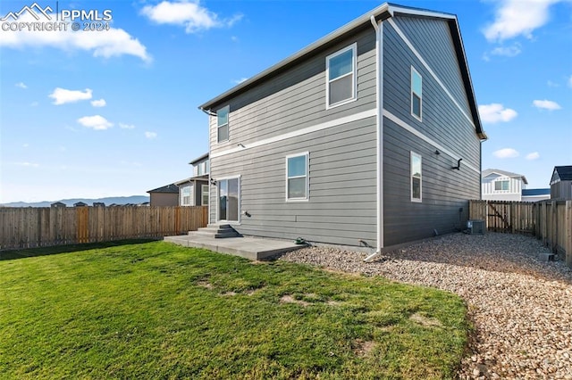 back of house with a patio, central AC, and a lawn