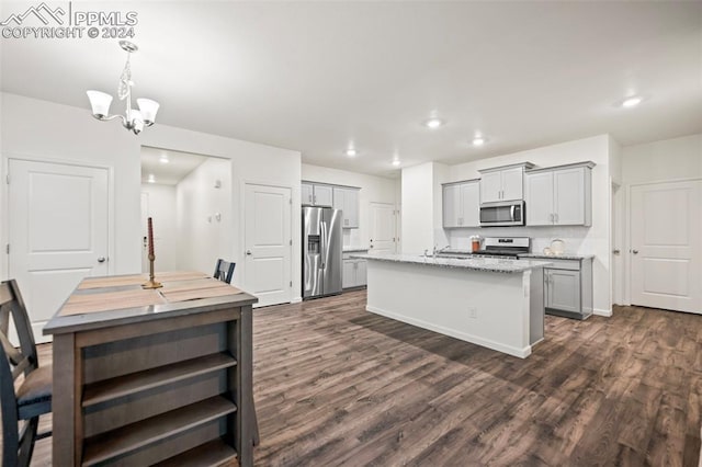 kitchen featuring gray cabinets, appliances with stainless steel finishes, a kitchen island with sink, and dark hardwood / wood-style floors