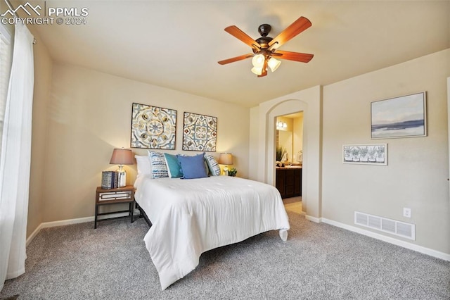 bedroom featuring ensuite bath, ceiling fan, and carpet