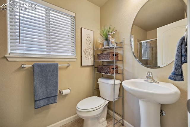 bathroom with tile patterned floors, toilet, and walk in shower