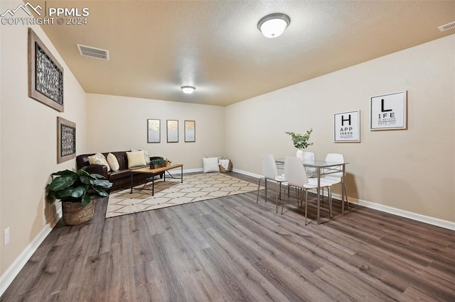 sitting room with hardwood / wood-style flooring and a textured ceiling