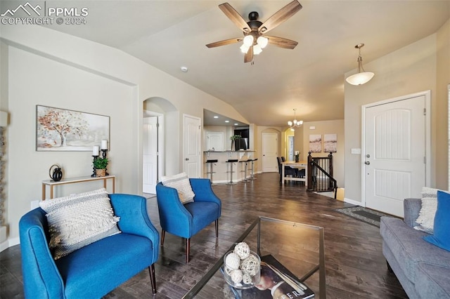 living room with ceiling fan with notable chandelier, dark hardwood / wood-style flooring, and lofted ceiling