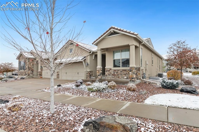 view of front of property featuring a garage and cooling unit