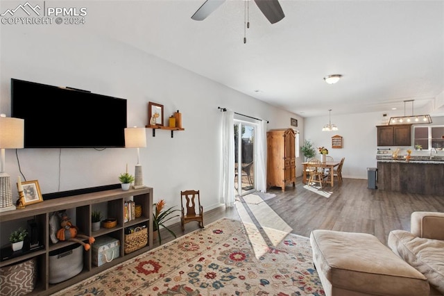 living room with hardwood / wood-style floors and ceiling fan with notable chandelier