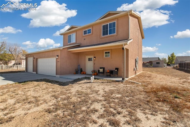 rear view of house featuring a patio and a garage