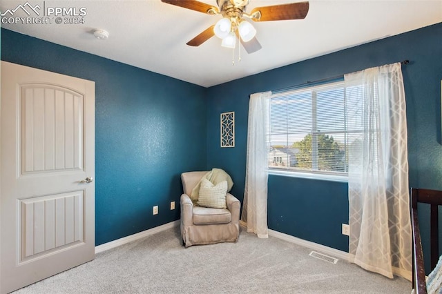 living area featuring carpet flooring and ceiling fan