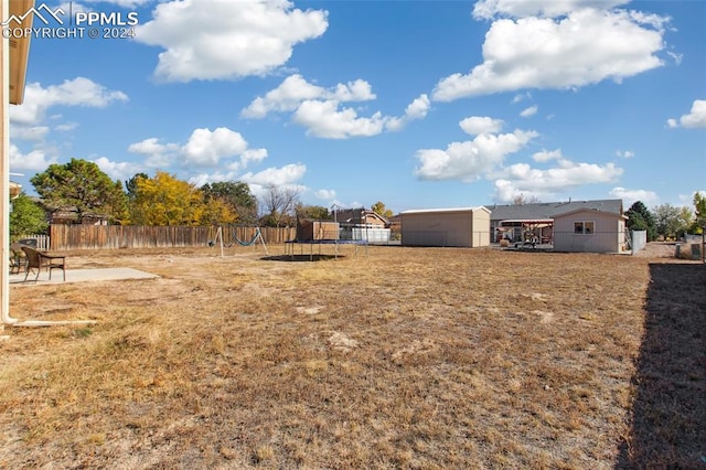 view of yard with a patio, a playground, a shed, and a trampoline