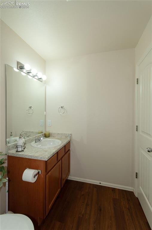 bathroom featuring vanity, hardwood / wood-style floors, and toilet