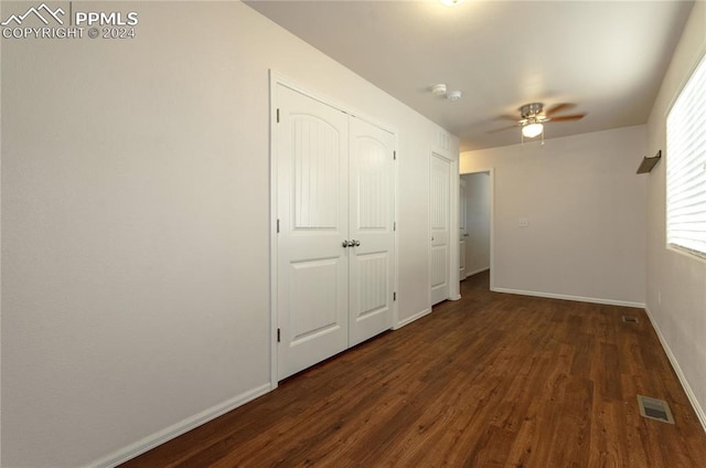 unfurnished bedroom featuring ceiling fan and dark hardwood / wood-style flooring