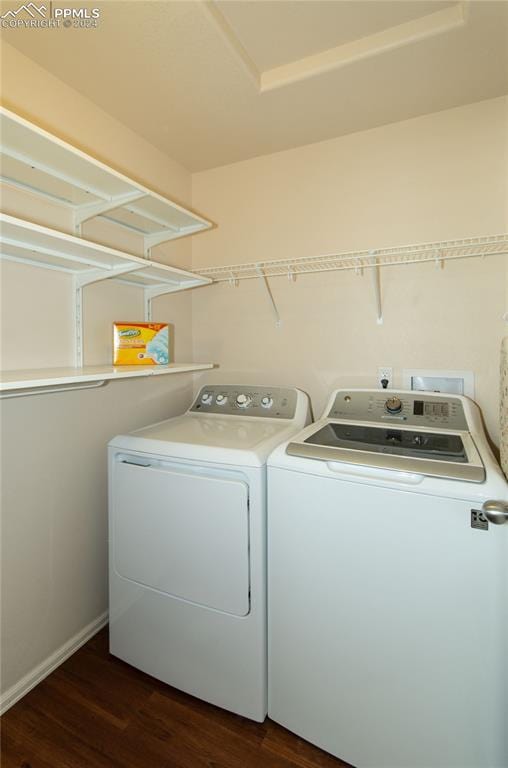 clothes washing area featuring dark wood-type flooring and separate washer and dryer