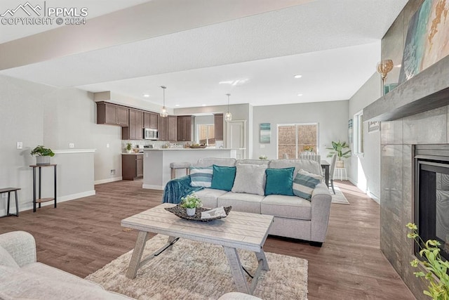 living room featuring hardwood / wood-style floors and a tile fireplace