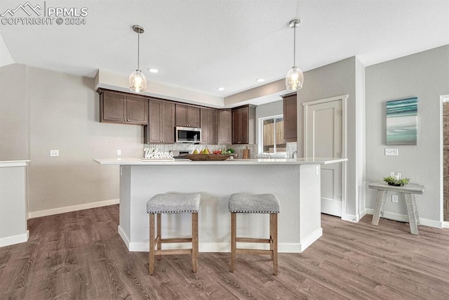 kitchen with dark brown cabinets, decorative light fixtures, and dark hardwood / wood-style floors