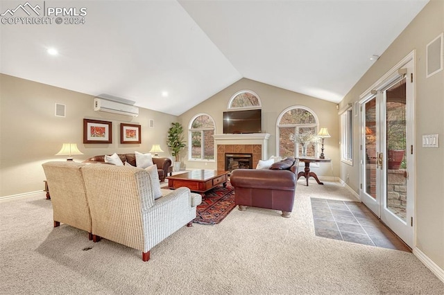 carpeted living room with an AC wall unit, vaulted ceiling, and a tile fireplace