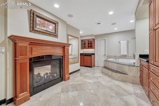 bathroom featuring vanity and a relaxing tiled tub