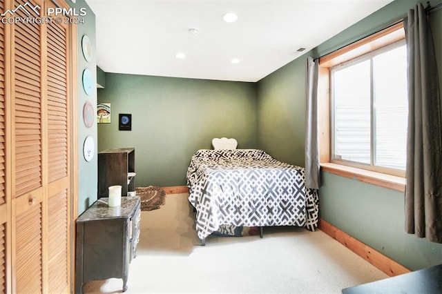 carpeted bedroom featuring multiple windows and a closet