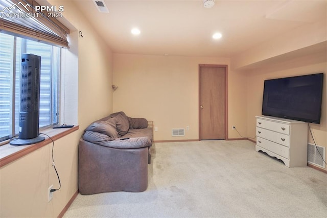 living area featuring light carpet and plenty of natural light