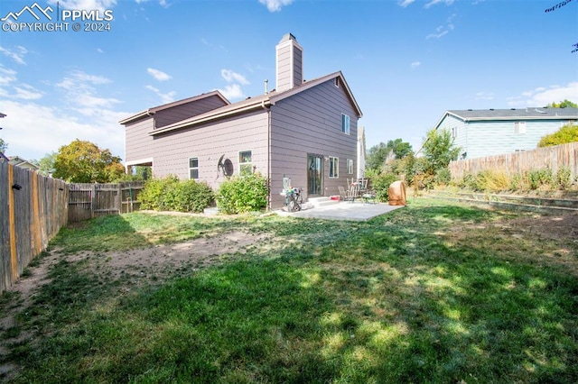 back of property with a yard and a patio