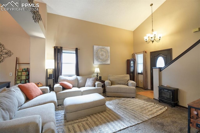 carpeted living room with a wood stove, high vaulted ceiling, and an inviting chandelier