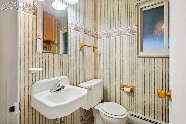 bathroom with sink, toilet, and a baseboard heating unit