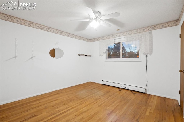 unfurnished room with ceiling fan, hardwood / wood-style flooring, and a baseboard radiator