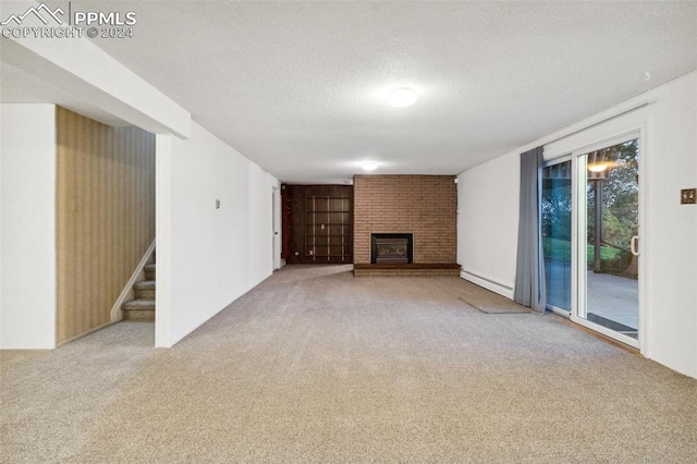 unfurnished living room featuring a textured ceiling, baseboard heating, carpet flooring, and a brick fireplace