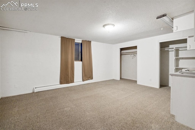 unfurnished bedroom featuring multiple closets, a textured ceiling, and light colored carpet