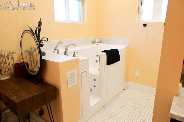 bathroom with plenty of natural light, tile patterned floors, and a tub