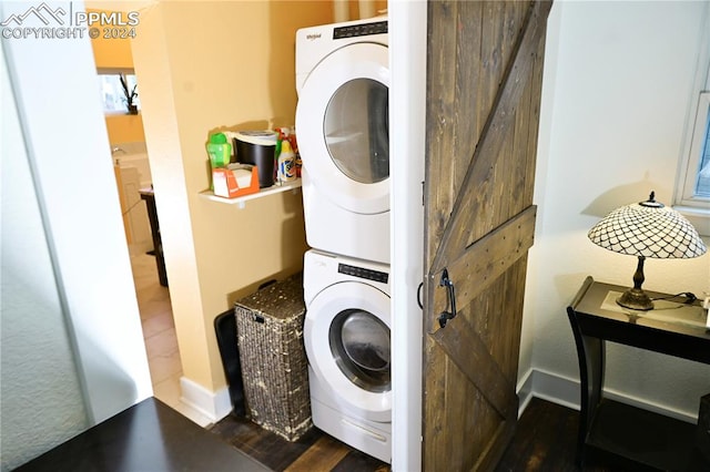 laundry room with dark wood-type flooring and stacked washing maching and dryer