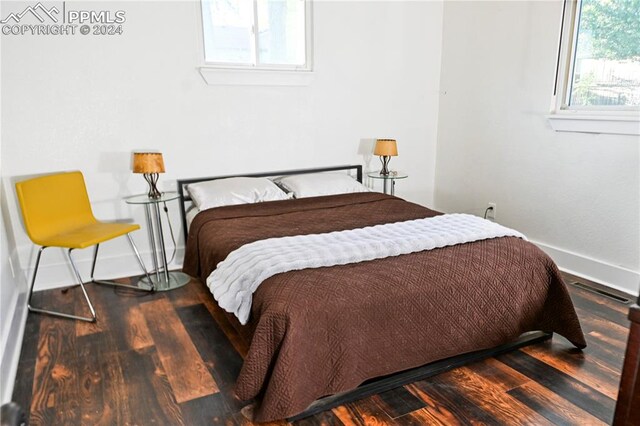 bedroom with dark hardwood / wood-style flooring