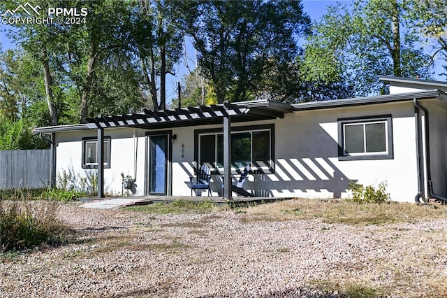 rear view of property featuring a patio area and a pergola