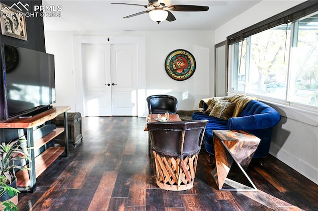 living room with dark wood-type flooring and ceiling fan