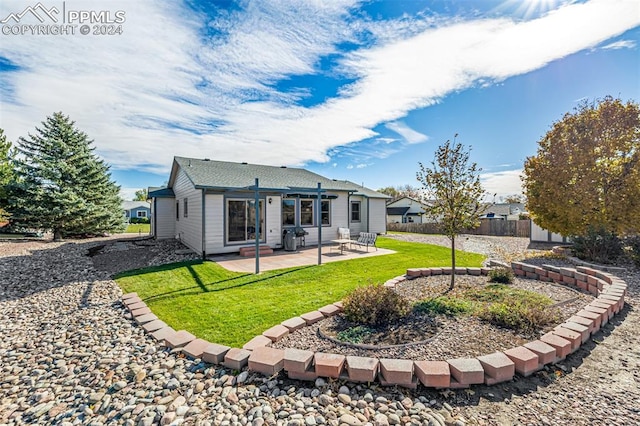 back of house featuring a lawn and a patio area