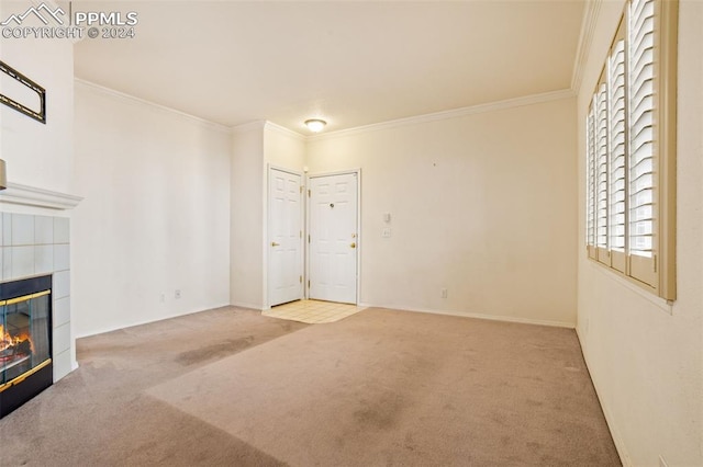 unfurnished living room with ornamental molding, a tile fireplace, and carpet