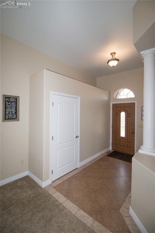 entryway with decorative columns and tile patterned flooring