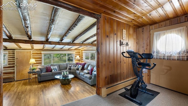 exercise area with hardwood / wood-style floors, a baseboard radiator, and wooden walls