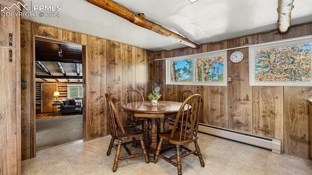 dining space featuring a baseboard heating unit, beamed ceiling, and wooden walls