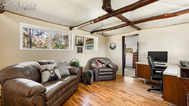 home office featuring light hardwood / wood-style floors and vaulted ceiling with beams