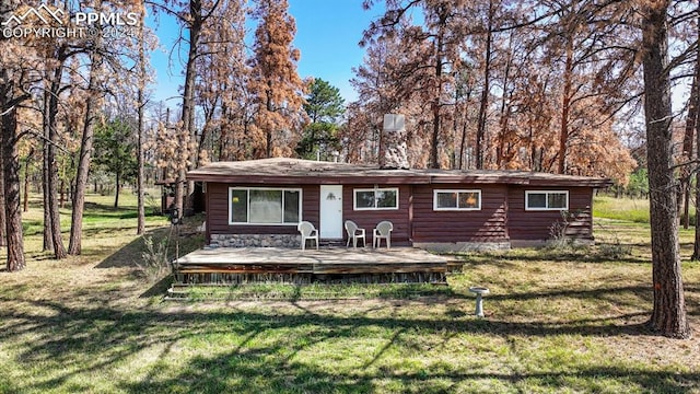 back of property with a wooden deck and a yard