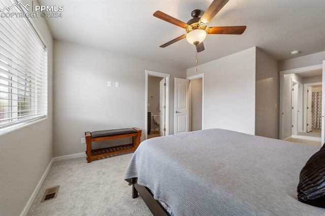 carpeted bedroom featuring ceiling fan and ensuite bathroom