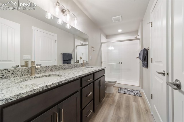 bathroom featuring vanity, walk in shower, toilet, and wood-type flooring