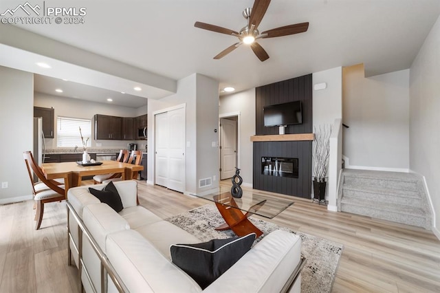 living room with light hardwood / wood-style flooring and ceiling fan