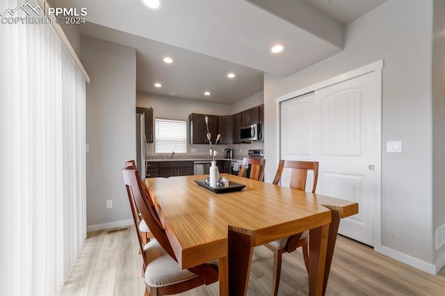 dining area featuring sink and light hardwood / wood-style flooring