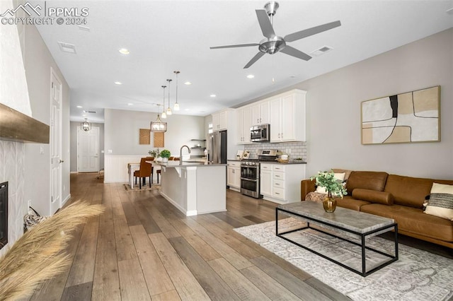 living room with sink, hardwood / wood-style flooring, and ceiling fan