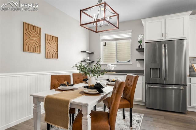 dining area with hardwood / wood-style flooring and a chandelier