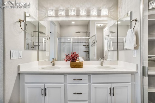 bathroom with vanity and a shower with door