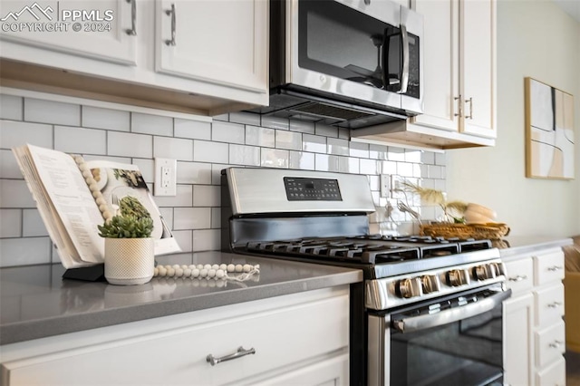 kitchen with white cabinets, decorative backsplash, and stainless steel appliances